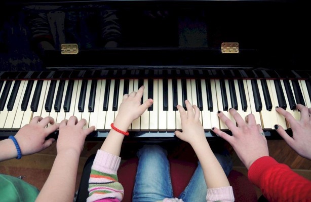 Image of children's hands on piano keys